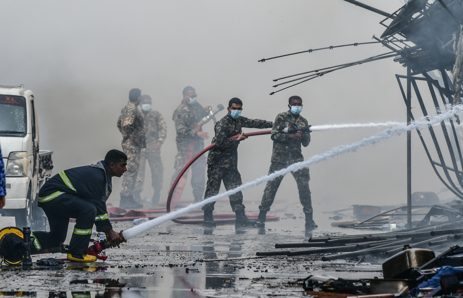 މާލޭގެ ދެކުނު ފަރާތު، ކުރީގެ އެއް ނަމްބަރު ކުނިކޮށި ހިމެނޭ "ނީލަން ފިހާރަ" އިގައި ހިނގާދިޔަ އަލިފާނުގެ ހާދިސާގައި އަލިފާންގަނޑު ނިއްވާލުމަށް އެމްއެންޑީއެފް އިން މަސައްކަތް ކުރަނީ.-- ފޮޓޯ: ނިޝާން އަލީ/ މިހާރު