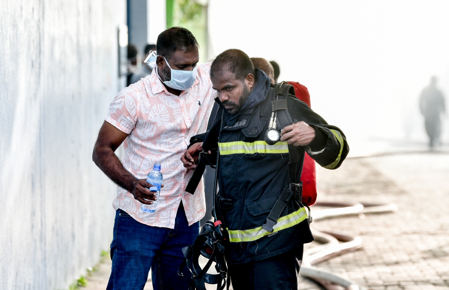 މާލޭގެ ދެކުނު ފަރާތު، ކުރީގެ އެއް ނަމްބަރު ކުނިކޮށި ހިމެނޭ "ނީލަން ފިހާރަ" އިގައި ހިނގާދިޔަ އަލިފާނުގެ ހާދިސާގައި އަލިފާންގަނޑު ނިއްވާލުމަށް މަސައްކަތް ކުރި މީހަކަށް އެހީތެރިވަނީ.-- ފޮޓޯ: ނިޝާން އަލީ/ މިހާރު