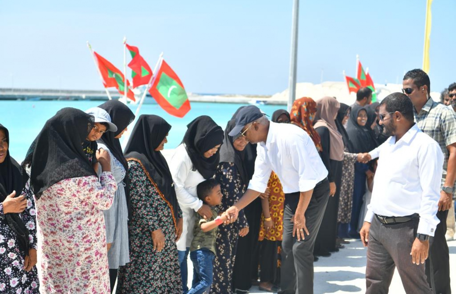 ރައިސް ހއ. އަށް ކުރެއްވި ދަތުރުފުޅުގައި ރަށެއްގެ ކުޑަކުއްޖަކާ ސަލާމް ކުރައްވަނީ-- ފޮޓޯ: މިހާރު