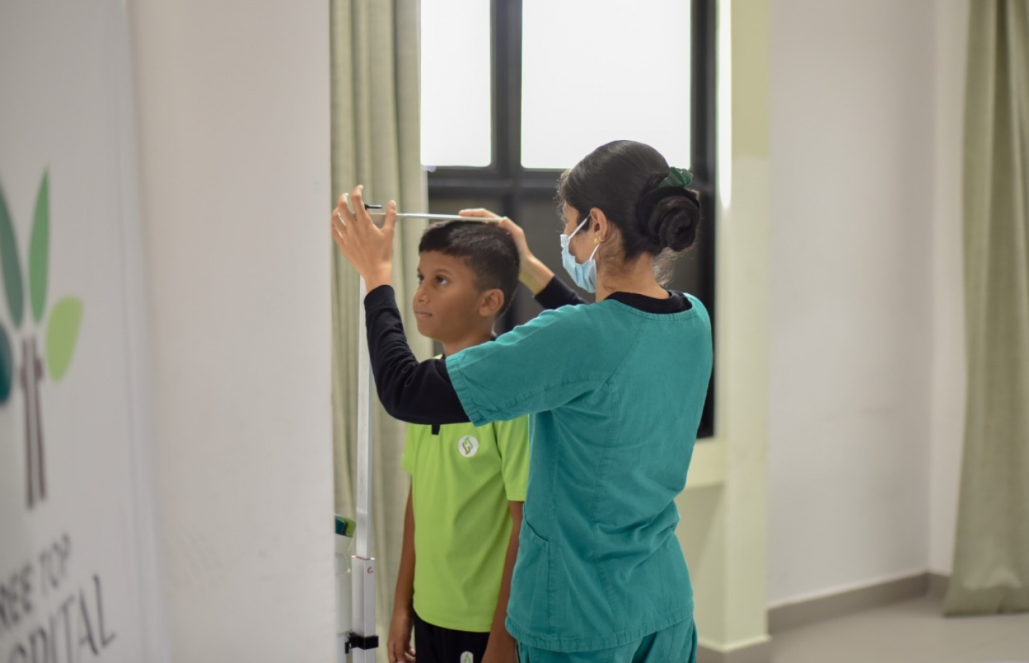 ހުރަވީ ސްކޫލުގައި ކުރިއަށް ގެންދިޔަ ހެލްތު ސްކްރީނިން ޕްރޮގުރާމުގައި ކުއްޖެއްގެ އިސްކޮޅު ބަލަނީ. -- ފޮޓޯ: ޓްރީ ޓޮޕް ހޮސްޕިޓަލް