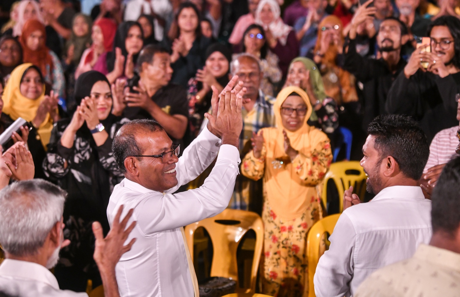 ރިޔާސީ ޕްރައިމަރީގެ ކެމްޕެއިން ނިންމުމުގެ ޖަލްސާ އަށް ނަޝީދު ވަޑައިގެން އަތް ޖައްސަވަނީ: އެ މަނިކުފާނަށް ތާއީދު ކުރާ އެމްޑީޕީގެ ވަރަށް ގިނަ ބަޔަކު މި ޖަލްސާގައި ބައިވެރިވި.--- ފޮޓޯ: ފަޔާޒު މޫސާ | މިހާރު