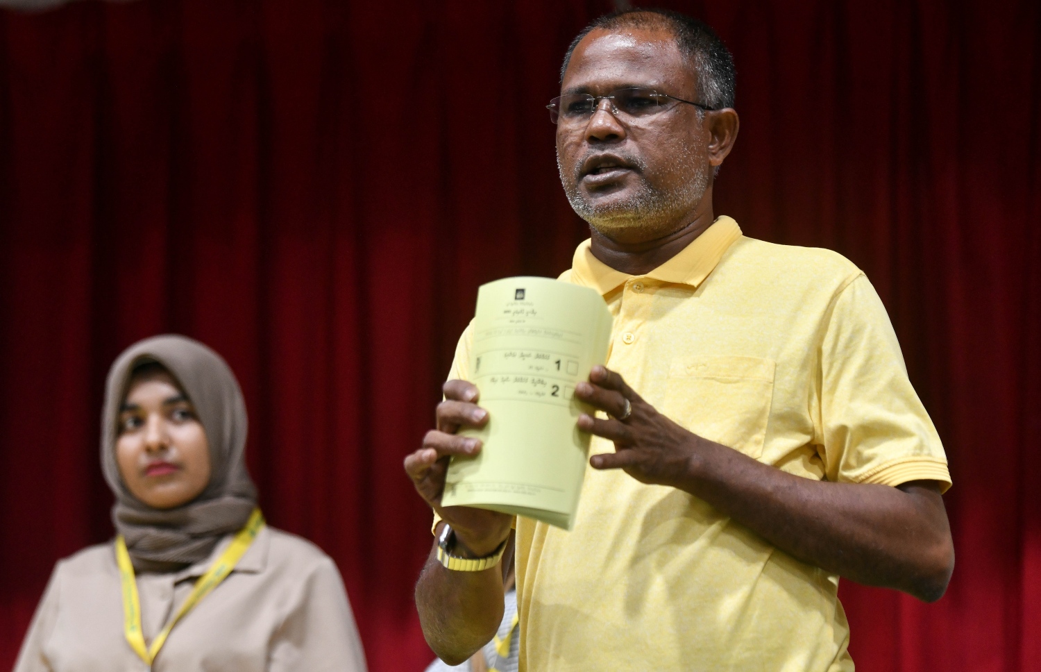 އެމްޑީޕީގެ ތާރީހުގައި ބާއްވާ އެންމެ ވާދަވެރި އެމްޑީޕީ ރިޔާސީ ޕްރައިމަރީގެ ވޯޓުލާން ފެށުމަށް އިސްކަންދަރު ސްކޫލުގައި ބަހައްޓާފައި ހުރި ވޯޓު ފޮއްޓަށް ވޯޓު ލުމުގެ ކުރިން އޮފިޝަލަކު ވޯޓު ކަރުދާސްކޮޅު ދައްކާލަނީ.-- ފޮޓޯ: ފަޔާޒް މޫސާ /މިހާރު