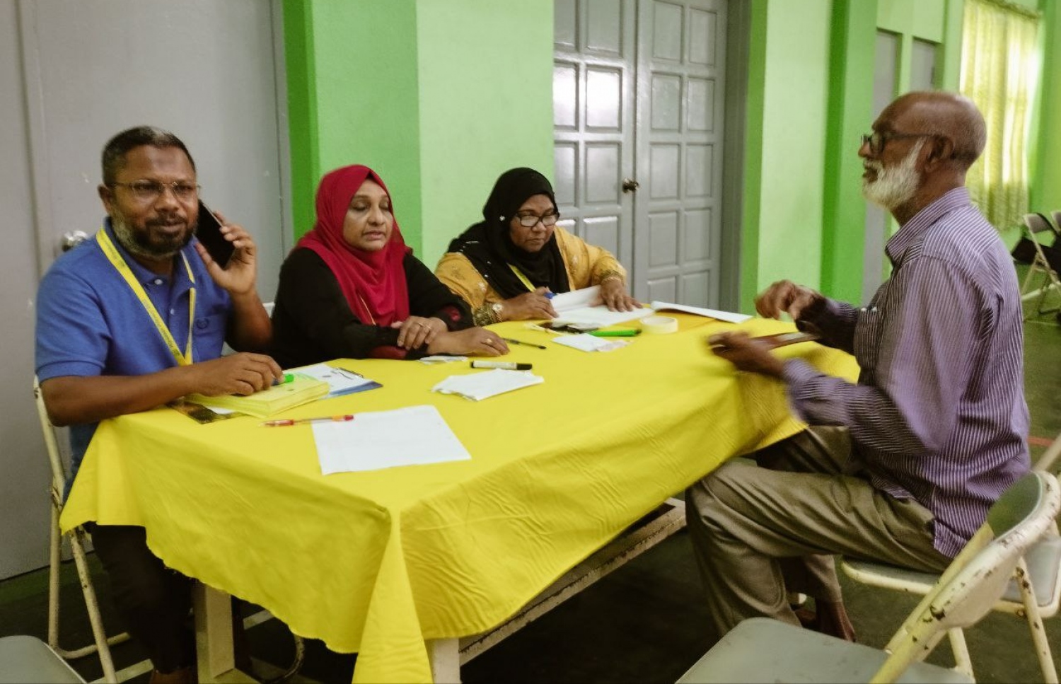 އެމްޑީޕީގެ ތާރީހުގައި ބާއްވާ އެންމެ ވާދަވެރި އެމްޑީޕީ ރިޔާސީ ޕްރައިމަރީގައި ކަލާފާނު ސްކޫލުގައި ބަހައްޓާފައ ހުރި ވޯޓު ފޮއްޓަށް މީހަކު ވޯޓުލުމަށް އޮފިޝަލުން މޭޒުކައިރީގައި.-- ފޮޓޯ: އަހުމަދު އަރުޝަމް /މިހާރު