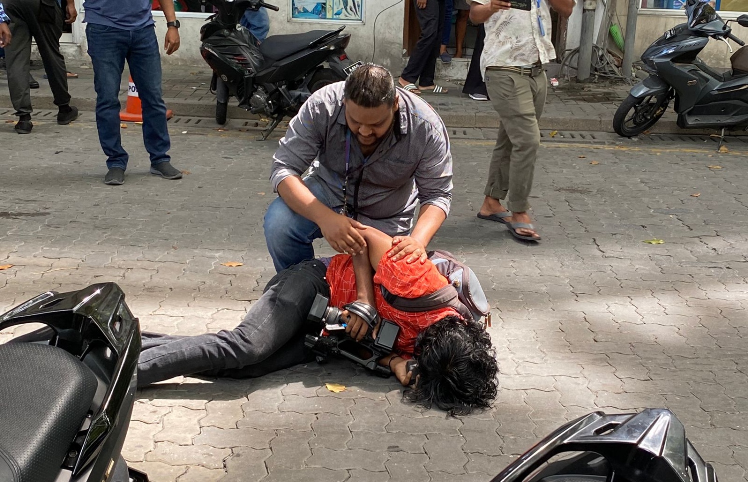 ޕީޕީއެމްގެ މުޒާހަރާގެ ތެރެއިން ޗެނަލް 13ގެ ނޫސްވެރިއަކަށް އަނިޔާވެގެން ބިންމައްޗަށް ވެއްޓިފައި -- ފޮޓޯ: ޕީޕީއެމް