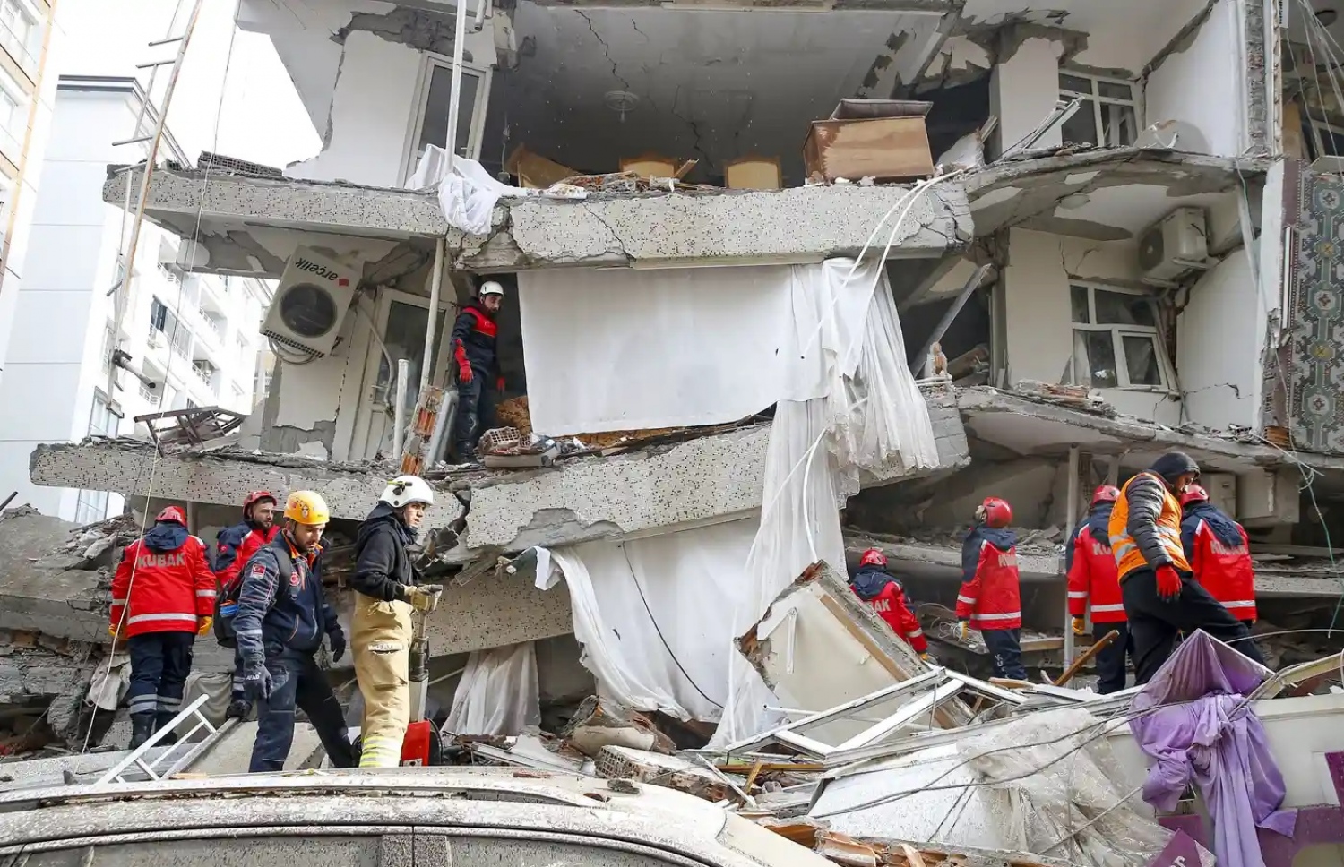 ތުރުކީ އާއި ސީރިއާގެ ބޯޑަރު ސަރަހައްދަށް އައި ބިންހެލުމުގައި އިމާރާތްތަކުގެ ދަށުވެފައިވާ މީހުން ސަލާމަތް ކުރުމަށް ރެސްކިއު ޓީމުން މަސައްކަތް ކުރަނީ --- ފޮޓޯ: އަނަޑަލޫ އެޖެންސީ