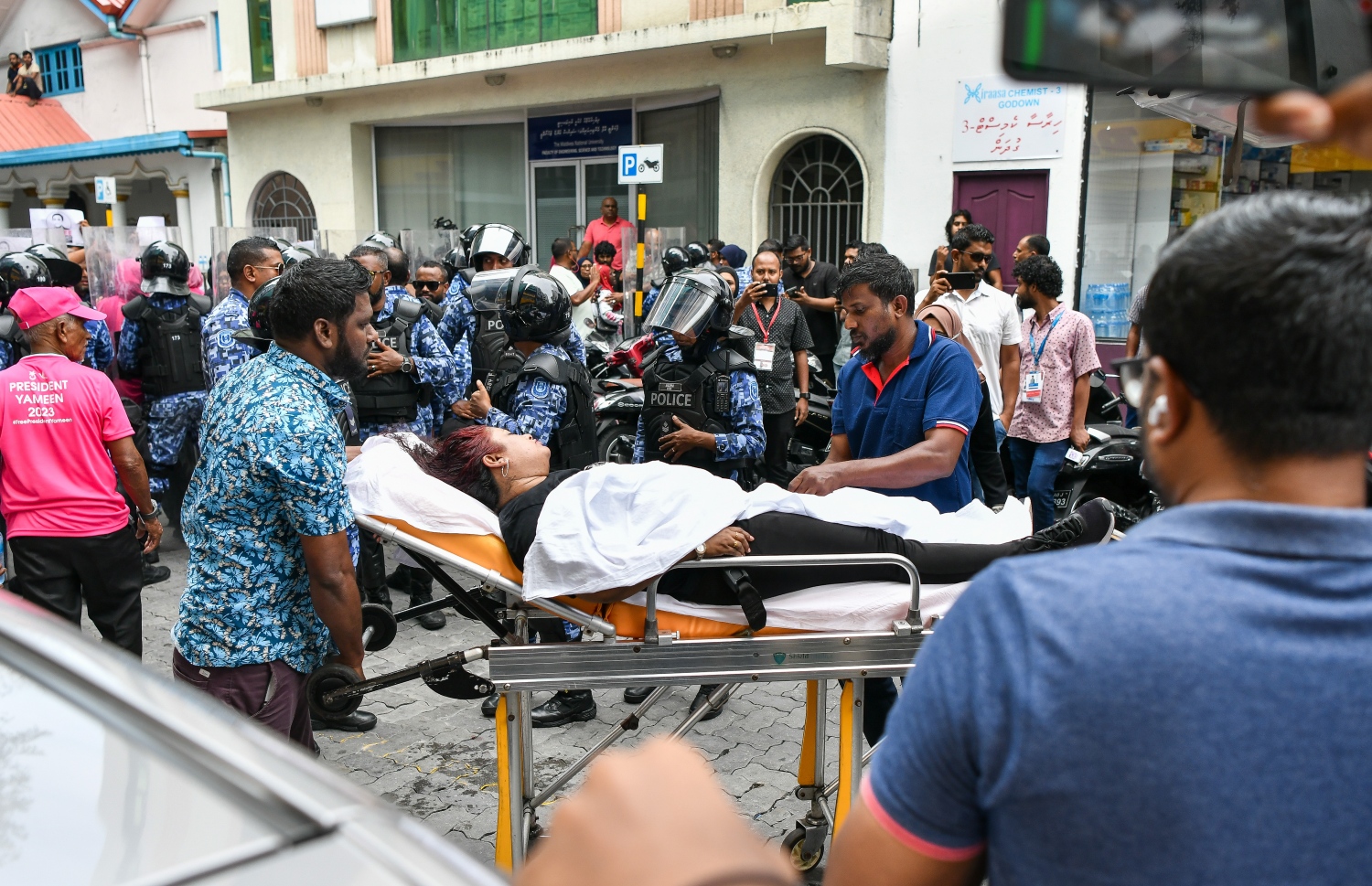 މުޒާހަރާގެ ބައިވެރިއަކަށް އަނިޔާވެގެން ހޮސްޕިޓަލަށް ގެންދަނީ: މުޒާހަރާގެ ބައިވެރިން ފަހަތަށް ޖައްސަން ފުލުހުން ޕެޕާ ސްޕްރޭ ވެސް ބޭނުންކުރި.---ފޮޓޯ: ފަޔާޒު މޫސާ| މިހާރު