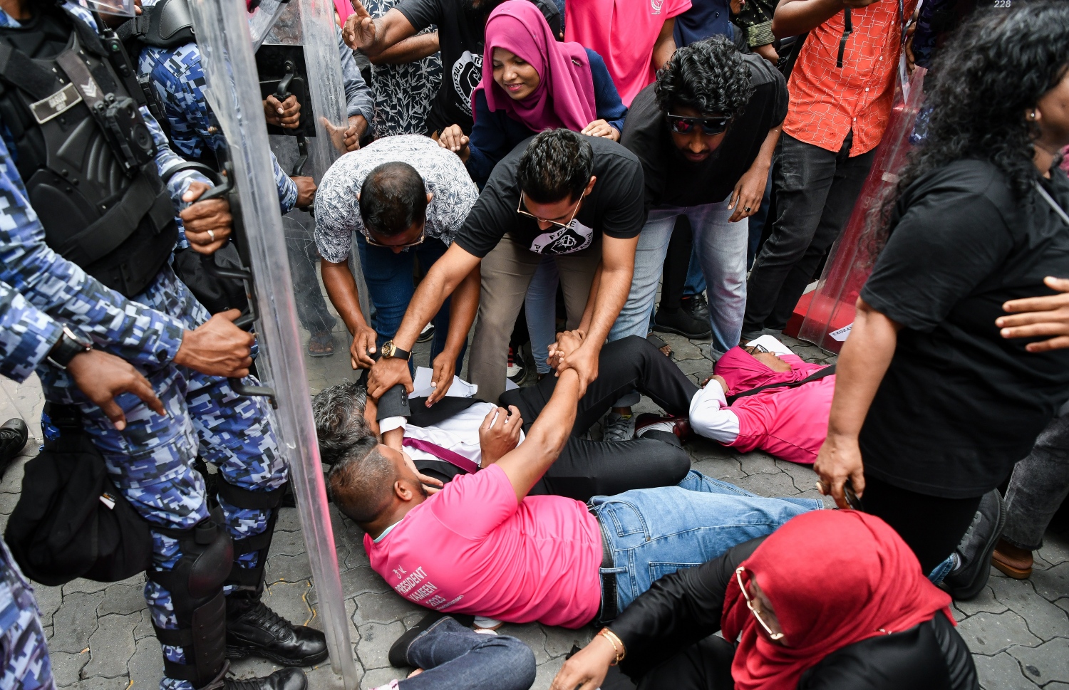 މުޒާހަރާގެ ބައިވެރިން ފަހަތަށް ޖެއްސުމަށް ފުލުހުން މަސައްކަތް ކުރަމުން އަންނައިރު، ފަރެސްމާތޮޑާ ދާއިރާގެ މެމްބަރު ހުސައިން މުހައްމަދު ލަތީފް މަގުމައްޗަށް ވެއްޓިފައި.--- ފޮޓޯ: ފަޔާޒު މޫސާ | މިހާރު