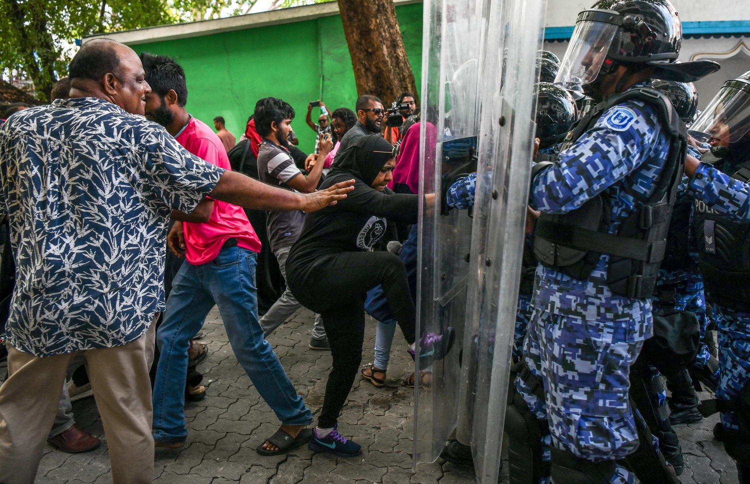 މުޒާހަރާގެ ބައިވެރިއަކު ފުލުހުންގެ ޝީލްޑްގައި ފައިން ޖަހަނީ: މުޒާހަރާ ކޮންޓްރޯލް ކުރުމަށް ފުލުހުން ވަނީ ބާރުގެ ބޭނުންކޮށް 17 މީހުން ހައްޔަރު ވެސް ކޮށްފައި.--- ފޮޓޯ: ފަޔާޒު މޫސާ | މިހާރު