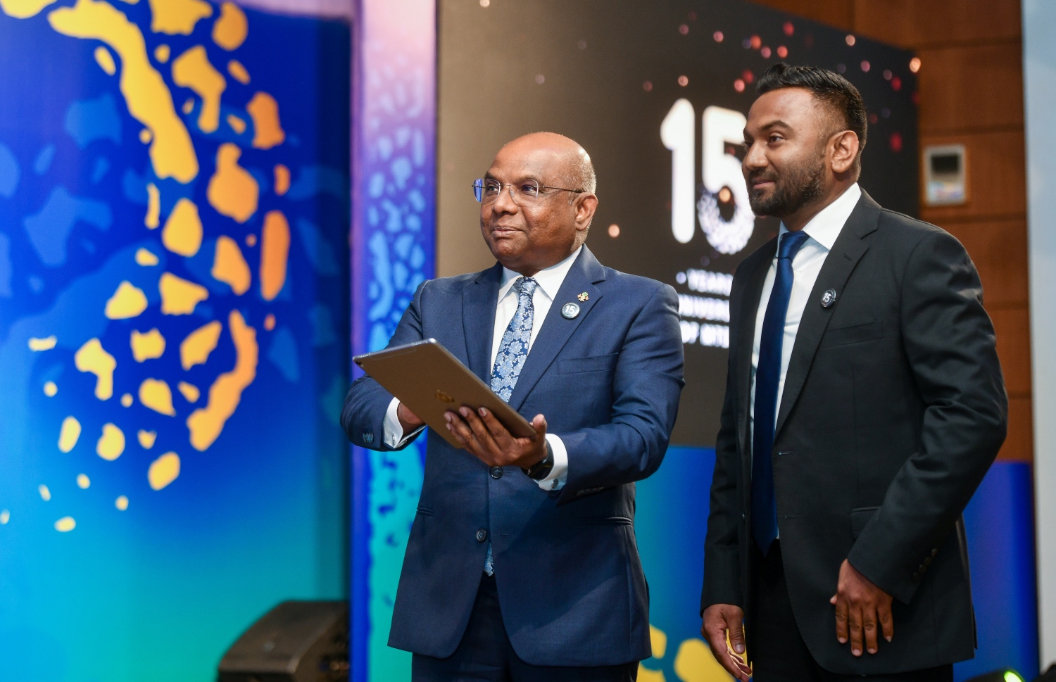 އެމްޓީޑީސީގެ 15 ވަނަ އަހަރީ ދުވަހާ ގުޅިގެން ކުރުނބާގައި ބޭއްވި ރަސްމިއްޔާތުގައި ފޮރިން މިނިސްޓަރު އަބްދުﷲ ޝާހިދު އެ ކުންފުނީގެ އާ ލޯގޯ ތައާރަފް ކޮށްދެއްވަނީ.-- ފޮޓޯ: ފަޔާޒް މޫސާ /މިހާރު