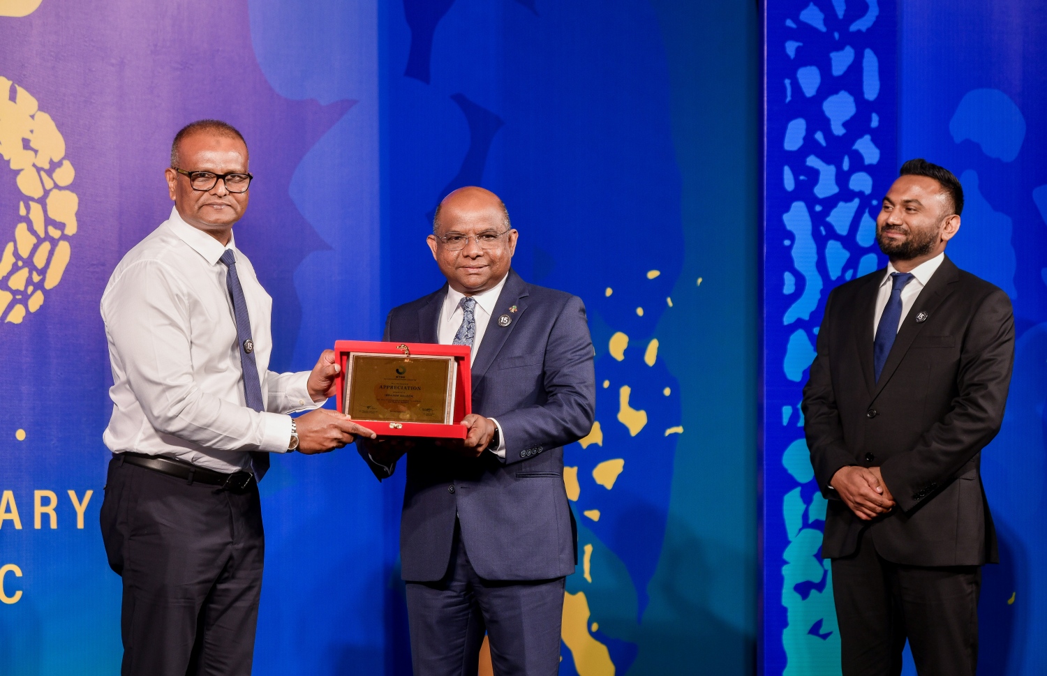 އެމްޓީޑީސީގެ 15 ވަނަ އަހަރީ ދުވަހާ ގުޅިގެން ކުރުނބާގައި ބޭއްވި ރަސްމިއްޔާތުގައި އަގު ވަޒަން ކުރުމުގެ ފިލައެއް އައިޖީއެމްއެޗްގެ ސީއީއޯ އިބްރާހިމް ސަލީމަށް(ވ) ފޮރިން މިނިސްޓަރު އަބްދުﷲ ޝާހިދު(މ) ދެއްވަނީ.-- ފޮޓޯ: ފަޔާޒް މޫސާ /މިހާރު