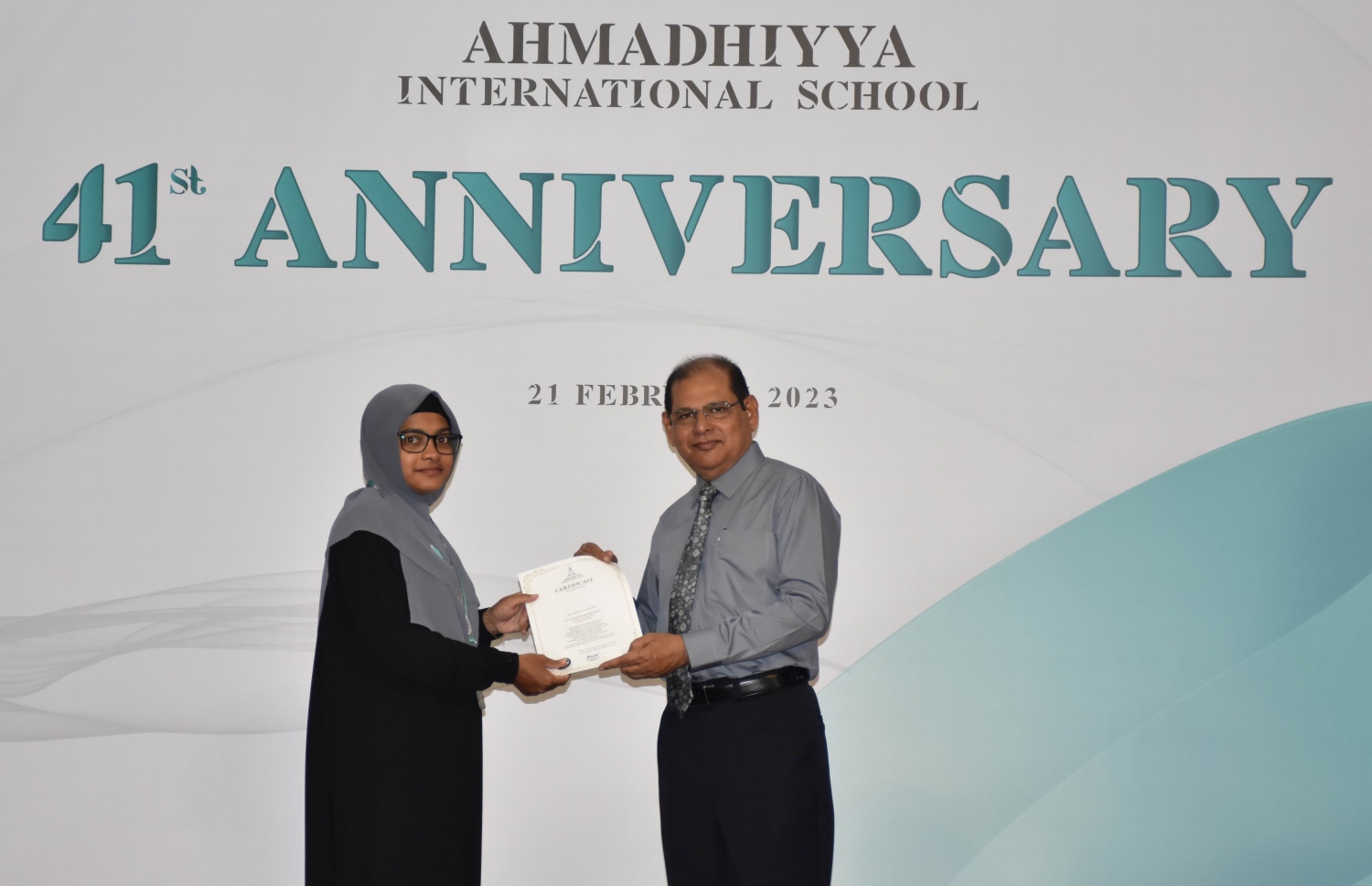 އަހުމަދިއްޔާގެ 41 ވަނަ އަހަރީ ދުވަސް ފާހަގަ ކުރުމަށް ބޭއްވި ޖަލްސާގައި ސްކޫލުގެ ޕްރިންސިޕަލް ޓީޗަރަކަށް ހަނދާނީ ލިޔުން ދެއްވަނީ -- ފޮޓޯ: އަހުމަދިއްޔާ