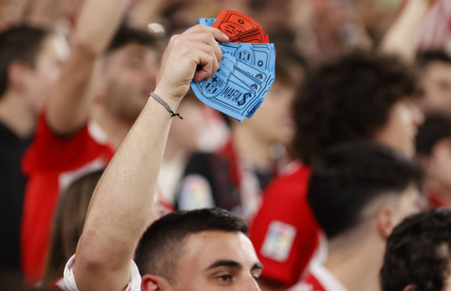 ބިލްބާއޯގެ ސަޕޯޓަރެއް ބާސެލޯނާގެ ލޯގޯ ޖަހައިފައިވާ ފޭކު ނޫޓުތަކެއް ހިފައިގެން.