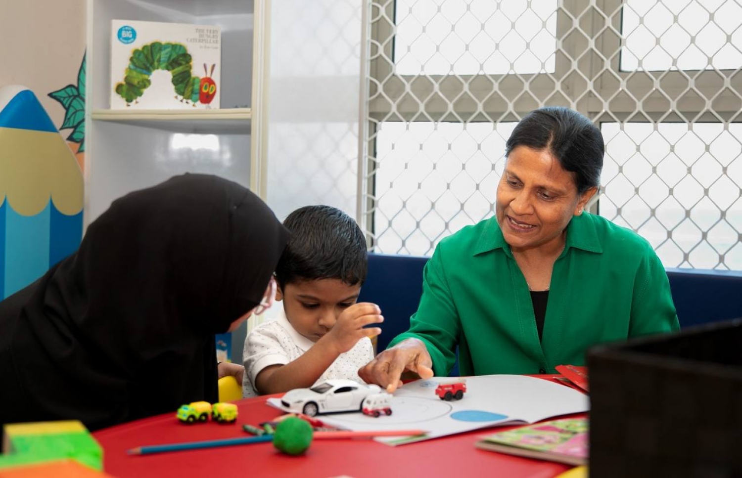 ޑޭކެއާ ސެންޓަރުން ހިދުމަތް ހޯދާ ކުއްޖަކަށް ފަސްޓް ލޭޑީ ފަޒްނާ އަހުމަދު (ކ) ފޮތަކުން އެއްޗެއް ދައްކަވަނީ. -- ފޮޓޯ: އެމްޕީއެލް