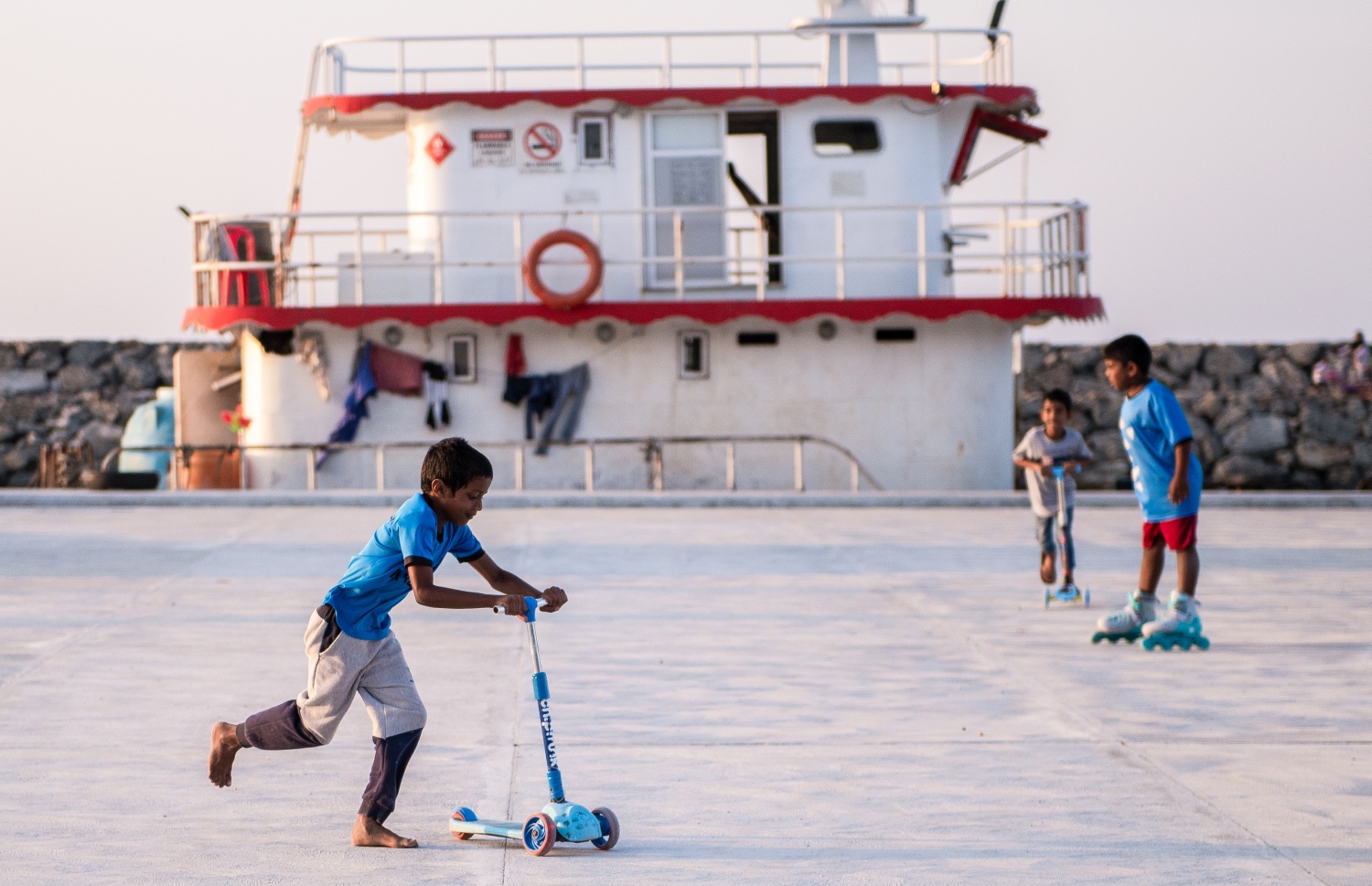 ބަނދަރު ސަރަހައްދުގައި ދަރަނބޫދޫ ކުޑަކުދިން ސްކޭޓް ކުރަނީ: މި ރަށުގެ ބަނދަރު ރަސްމީކޮށް އަދި ހުޅުވައިފައި ނުވިޔަސް ބަނދަރުގެ ބޭނުން މިހާރު ވަނީ ކުރަން ފަށައިފައި. މި އަހަރުގެ ތެރޭގައި ބަނދަރު ރަސްމީކޮށް ހުޅުވާނެ -- ފޮޓޯ: ވިޝާހު ޒަރީރު/ މިހާރު