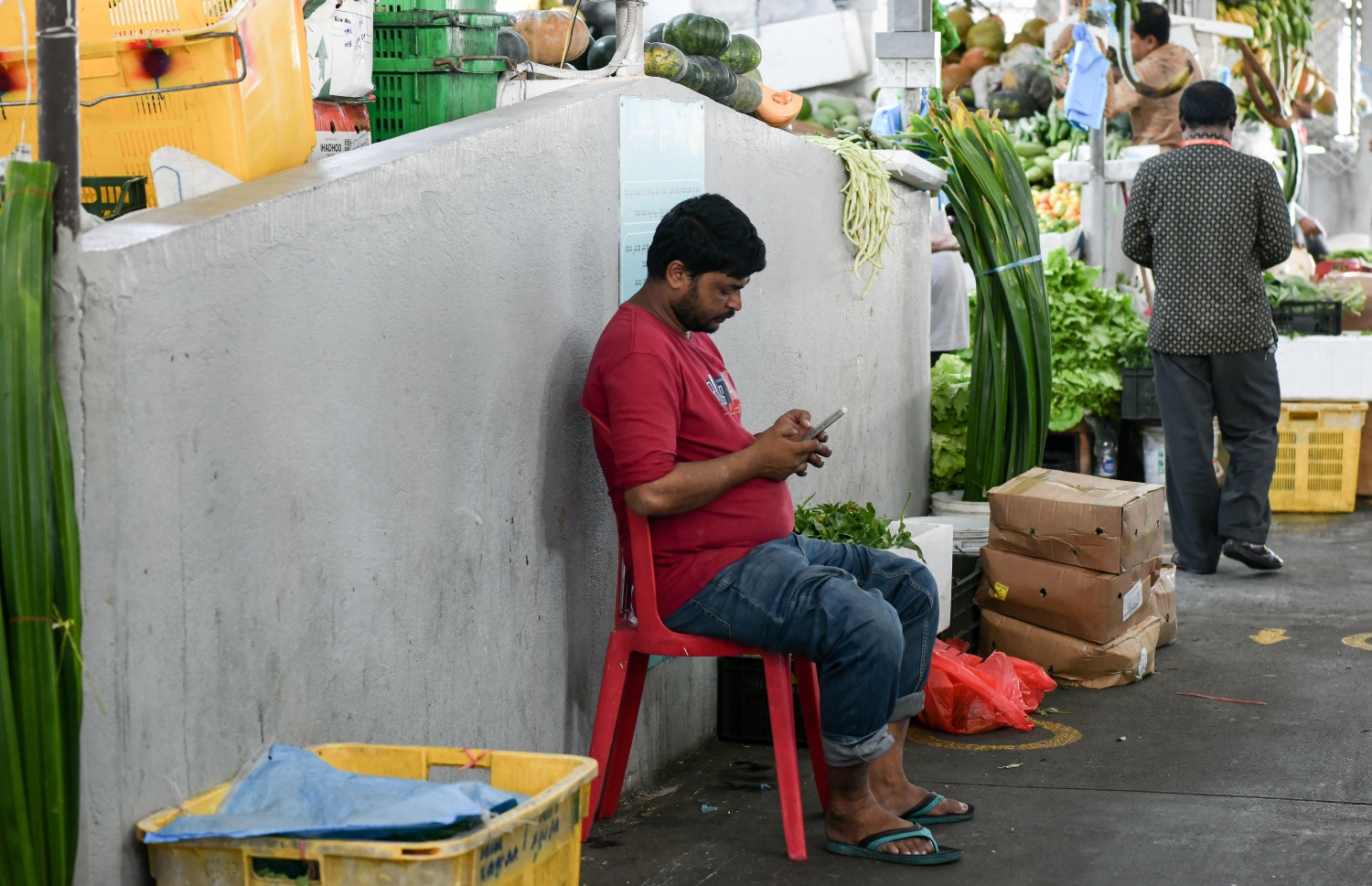 މާރުކޭޓު ގޮޅިއެއްގައި އިން މީހަކު ފޯނާ ކުޅެނީ: ކުރީގެ ރޯދަ މަސްތަކުގައި އެންމެ ބާރު ބޮޑު ގަޑިތަކުގައި މިފަހަރު މާރުކޭޓު ފެންނަނީ ފަޅުކޮށް. -- ފޮޓޯ: ނިޝާން އަލީ/ މިހާރު