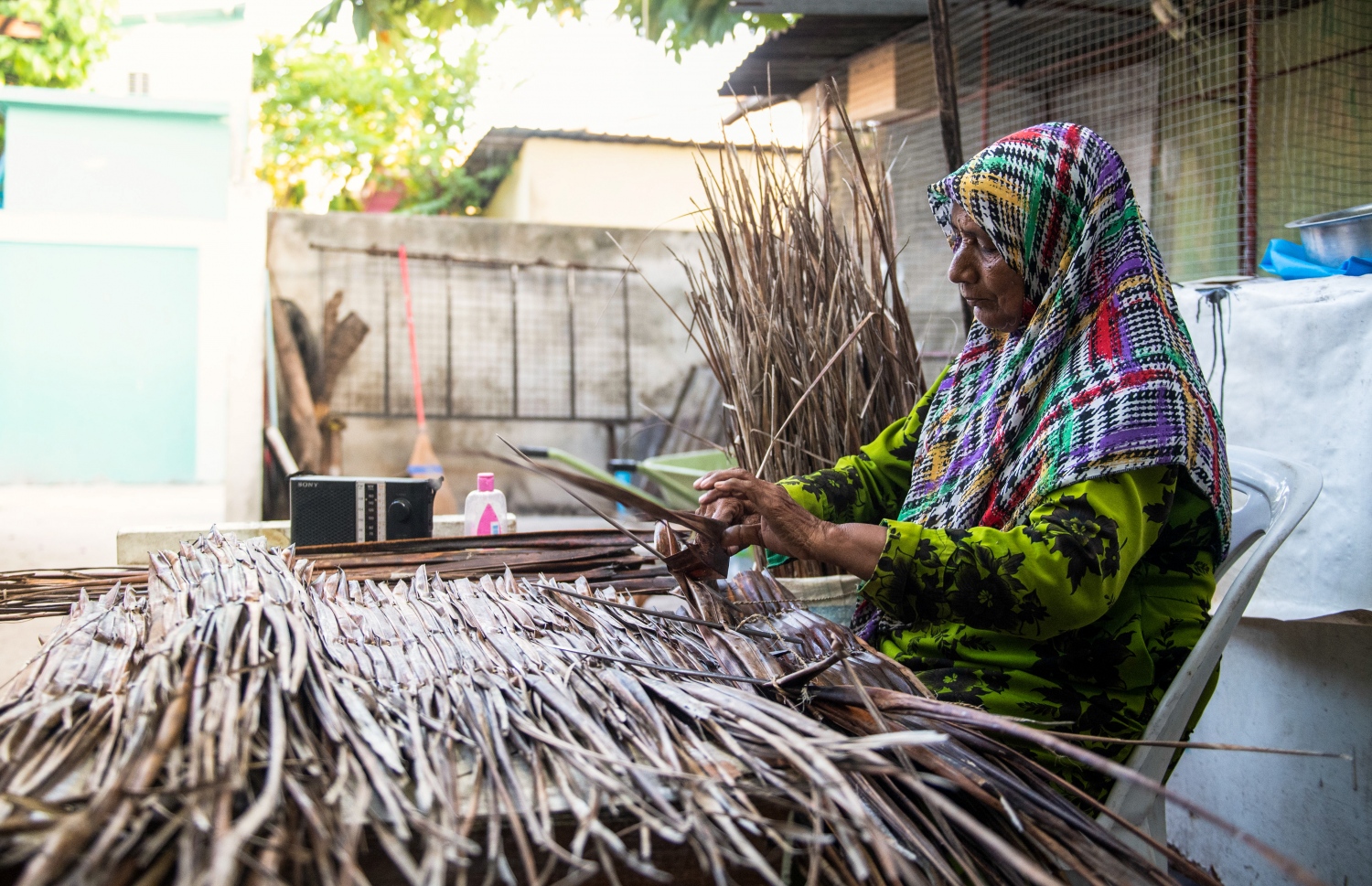 ކައިރީގައި ރޭޑިއޯއެއް ބަހައްޓައިގެން، އޭނާ ކޮންމެ ދުވަހަކު ހެނދުން ފެށިގެން ގޮސް، މަސައްކަތް ނިމެންދެން އެކަމުގައި އުޅޭ. އޭނާގެ ދަރިން ބުނާ ގޮތުން "މަންމަ" މިކަން ނުކުރާ ދުވަހެއް އެ މީހުންނަކަށް ނުފެނޭ. އަދި ފަންގިވިނުމަކީ މަރިޔަމްގެ ހަޔާތުގެ އެއްބައި-- ފޮޓޯ: ވިޝާހު ޒަރީރު/ މިހާރު
