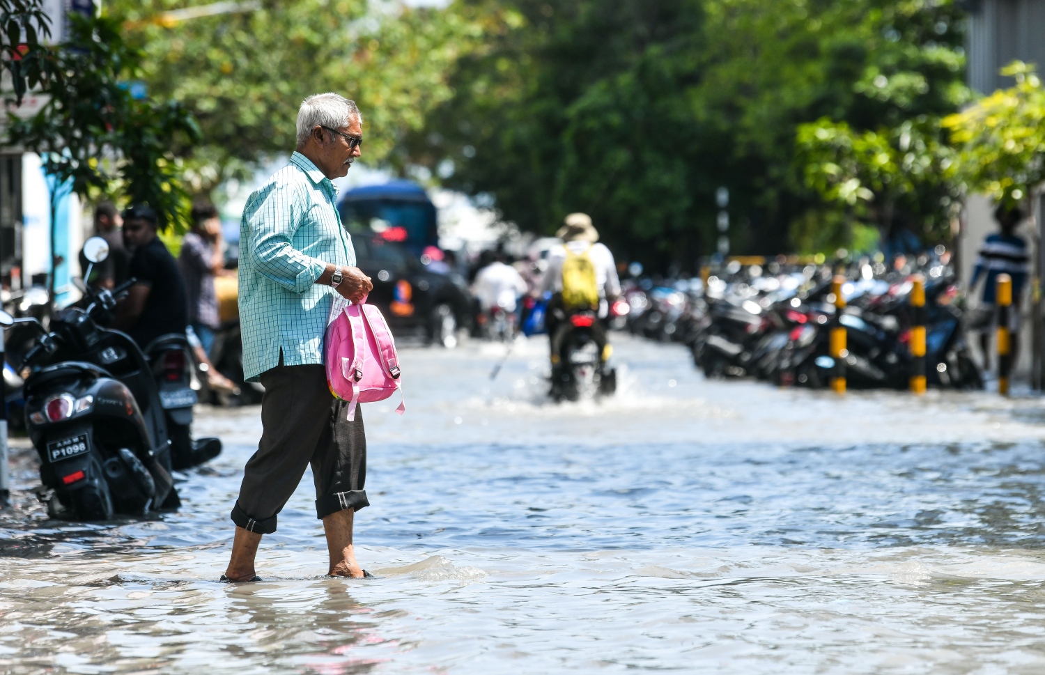 ފެން ބޮޑުވެފައިވާ މަގަކުން މީހަކު ހުރަސް ކުރަނީ: މިއަދު ވެހުނު ބޯ ވާރޭގައި މާލޭގެ ބޮޑެތި މަގުތަކުގައި އާދަޔާ ހިލާފަށް ފެން ބޮޑުވި.--- ފޮޓޯ: ފަޔާޒު މޫސާ | މިހާރު