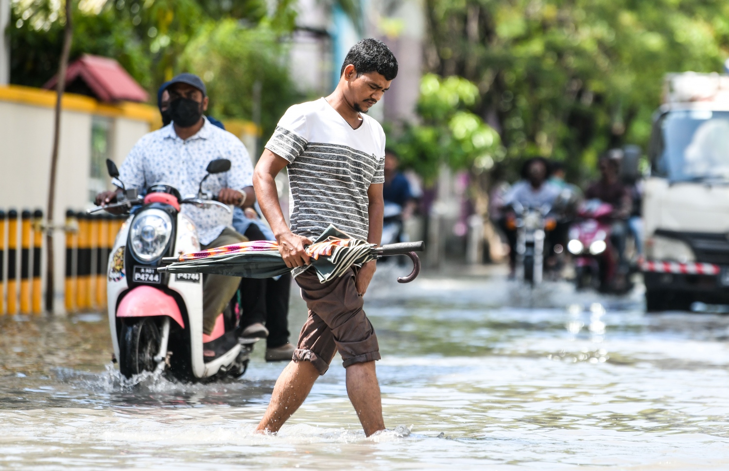 މާލޭގައި މަސައްކަތްކުރާ ބިދޭސީއަކު ކުޑައެއް ހިފައިގެން ފެންގަނޑު ހުރަސްކުރަނީ.--- ފޮޓޯ: ފަޔާޒު މޫސާ | މިހާރު