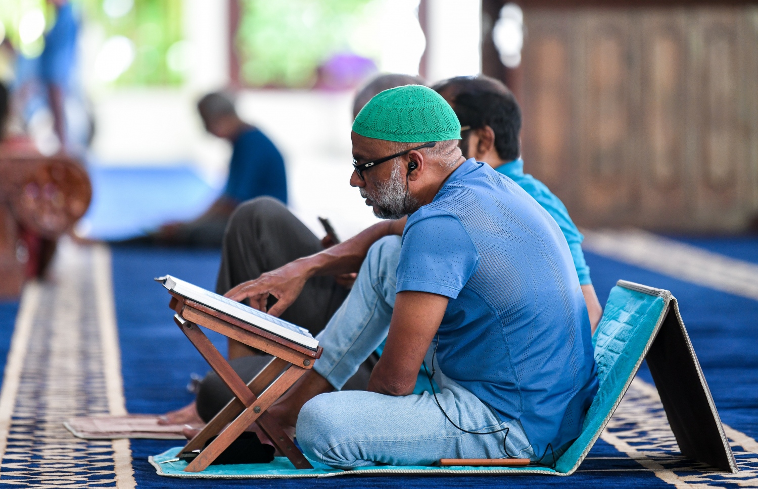 އިސްލާމީ މަރުކަޒުގައި ޖަމާއަތުގައި ކުރި މެންދުރު ނަމާދަށް ފަހު، މީހަކު ގުރުއާން ކިޔަވަނީ.---ފޮޓޯ: ފަޔާޒް މޫސާ/މިހާރު