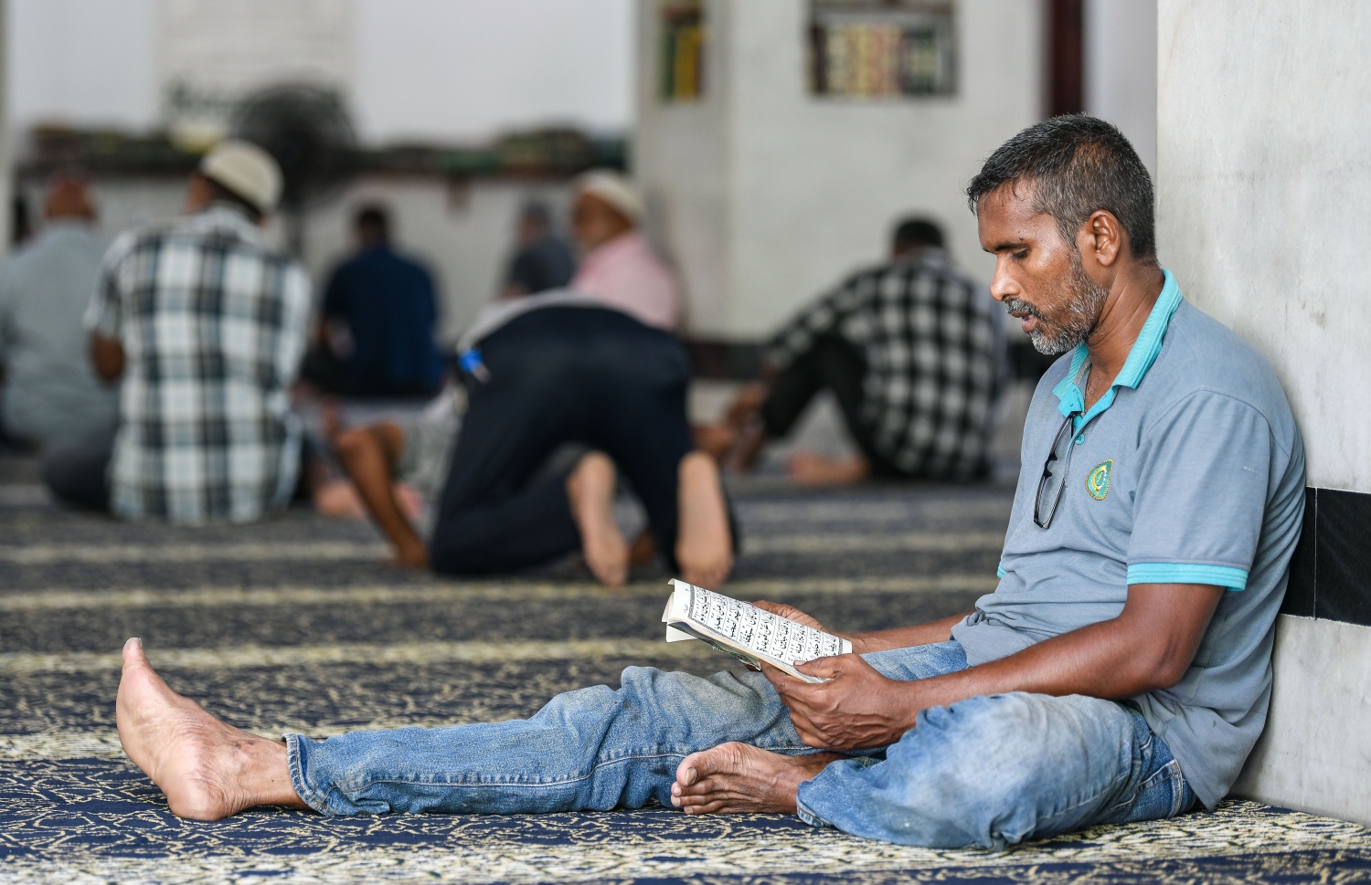 އިސްލާމީ މަރުކަޒުގައި ޖަމާއަތުގައި މިއަދު ކުރި މެންދުރު ނަމާދަށް ފަހު، މީހަކު ގުރުއާން ކިޔަވަނީ.---ފޮޓޯ: ފަޔާޒް މޫސާ/މިހާރު