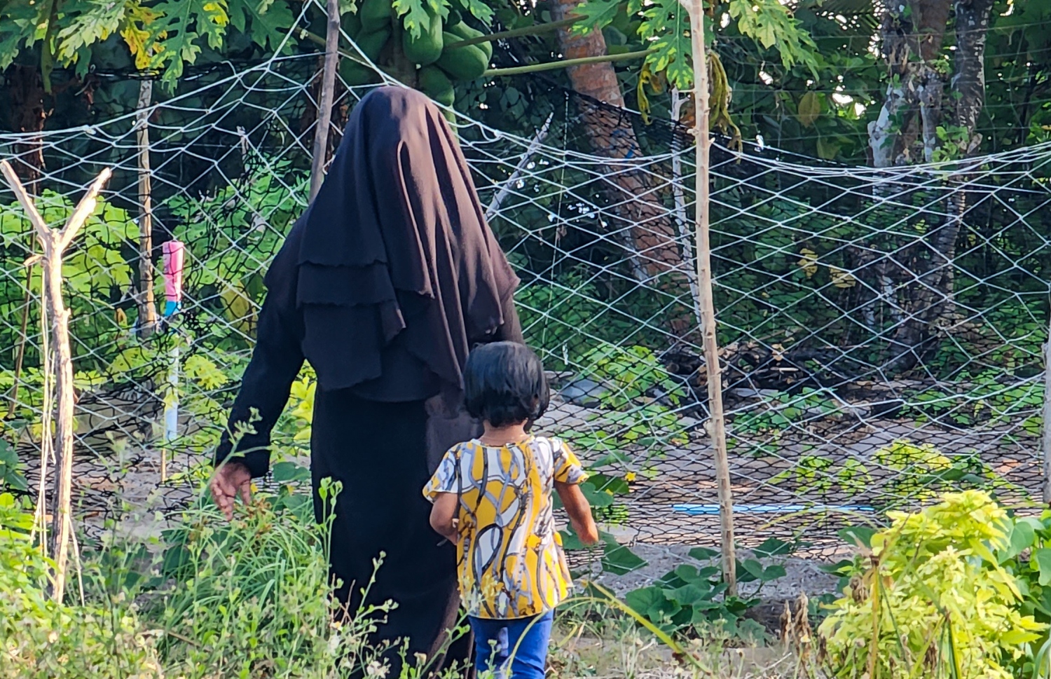 ޣާލިބާ އޭނާގެ ދަރިފުޅާ އެކު ދަނޑަށް ދަނީ: ދަނޑުވެރި ކަމުގައި އޭނާ އަށް ދެން އެހީތެރިކަން ފޯރުކޮށްދޭ މީހަކީ އޭނާގެ ފިރިމީހާ. އެ ތަކެތި މާލެ ފޮނުވުމުގައި އޭނާ އަށް ފިރިމީހާގެ އެހީތެރިކަން ލިބޭ -- ފޮޓޯ: މިހާރު