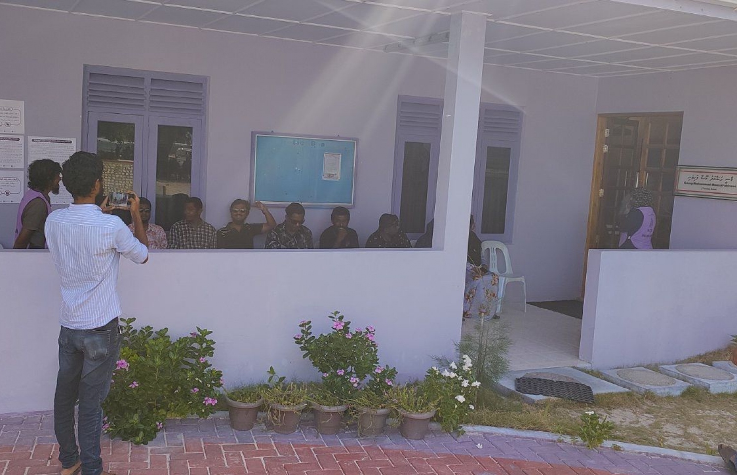 ގުރައިދޫގައި ވޯޓުލާން ތިބި ބައެއް ޒުވާނުން އިށީނދެގެން.