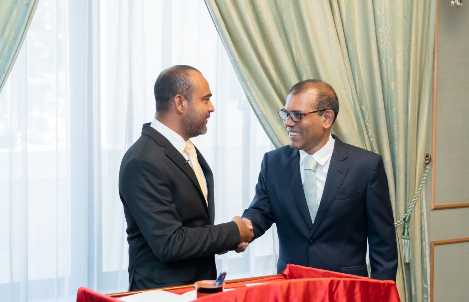 ޝާޒް، މަޖިލިހުގެ މެމްބަރުކަމުގެ ހުވާ މިއަދު ކުރެއްވުމާ ގުޅިގެން، އޭނާއާ މަޖިލިހުގެ ރައީސް ނަޝީދު ސަލާމް ކުރައްވަނީ.---ފޮޓޯ: މަޖިލިހުގެ އިދާރާ