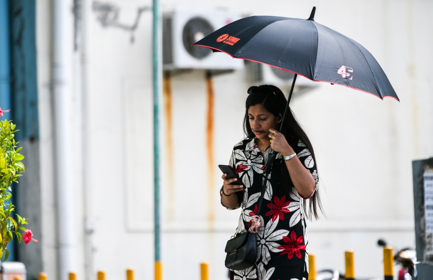 ފުލުހުންގެ އިދާރާ ކައިރިން ހިނގާފައި ދިޔަ އަންހެނަކު ހޫނު ގަދަވުމުގެ ސަބަބުން ކުޑަ ނަގައިގެން ދަނީ.---ފޮޓޯ: ފަޔާޒު މޫސާ| މިހާރު