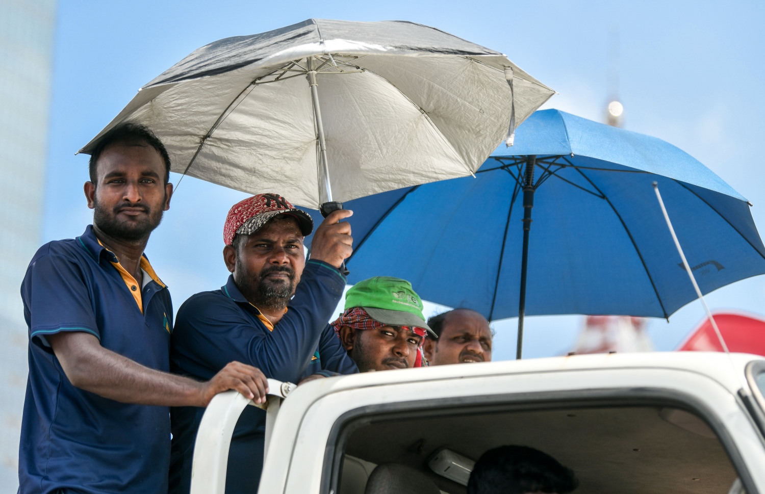 ޓީޖެޓީ ސަރަހައްދުގައި މުދާ އަރުވަން މަޑުކޮށްގެން އޮތް ޕިކަޕެއްގައި ތިބި ބިދޭސީންތަކެއް އަވި ގަދަކަމުން ކުޑަ ނަގައިގެން.--- ފޮޓޯ: ފަޔާޒު މޫސާ | މިހާރު