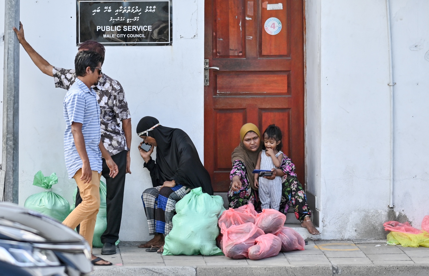 ދިވެހިންނަށް ބެހުމަށް ޗަމްޕާ ބްރަދާސްގެ ފަރާތުން ހަދިޔާކުރި ކަރަ އާއި ކާށި ލިބުނު އާއިލާއެއް، ސިޓީ ކައުންސިލުގެ އާންމު ހިދުމަތްތަކާ ބެހޭ އިމާރާތުގެ ބޭރުގައި މަޑުކޮށްލައިގެން.--- ފޮޓޯ: ނިޝާން އަލީ / މިހާރު