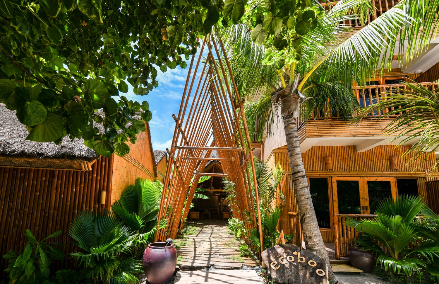 އީކޯބޫގެ ރިސެޕްޝަންގެ ބޭރު: ދެ ފަރާތުން އޮނު ވޯކްވޭއެއް ހަދާފައިވާ މި ތަނުގެ ތަޅުންގަނޑުގައި ބޭނުންކޮށްފައި ވަނީ ސުނާމީގައި ތިނަދު އަށް ލެއްގި ބޮޑު ގަހެއްގެ ބައިބައި ފޮތިކޮށްގެން. --- ފޮޓޯ: ފަޔާޒު މޫސާ| މިހާރު