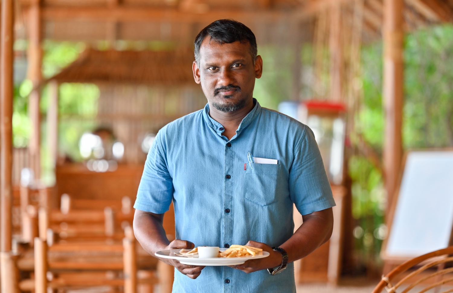 އީކޯބޫގެ ރެސްޓޯރަންޓްގައި މަސައްކަތްކުރާ ބޭރު ވެއިޓަރަކު ގެސްޓުންނަށް މެންދުރުގެ ކެއުން ގެންގޮސް ދެނީ -- ފޮޓޯ: ފަޔާޒް މޫސާ | މިހާރު