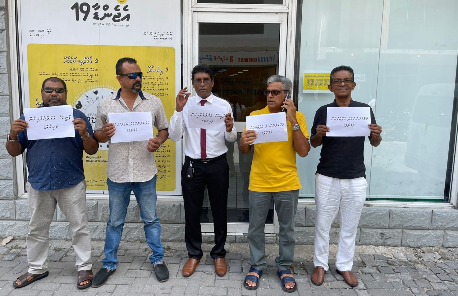 އެމްޑީޕީ އޮފީސް ކައިރިއަށް އެއްވި މީހުން ގަނޑުތައް ހިފައިގެން ޝުއޫރުފާޅުކުރަނީ.