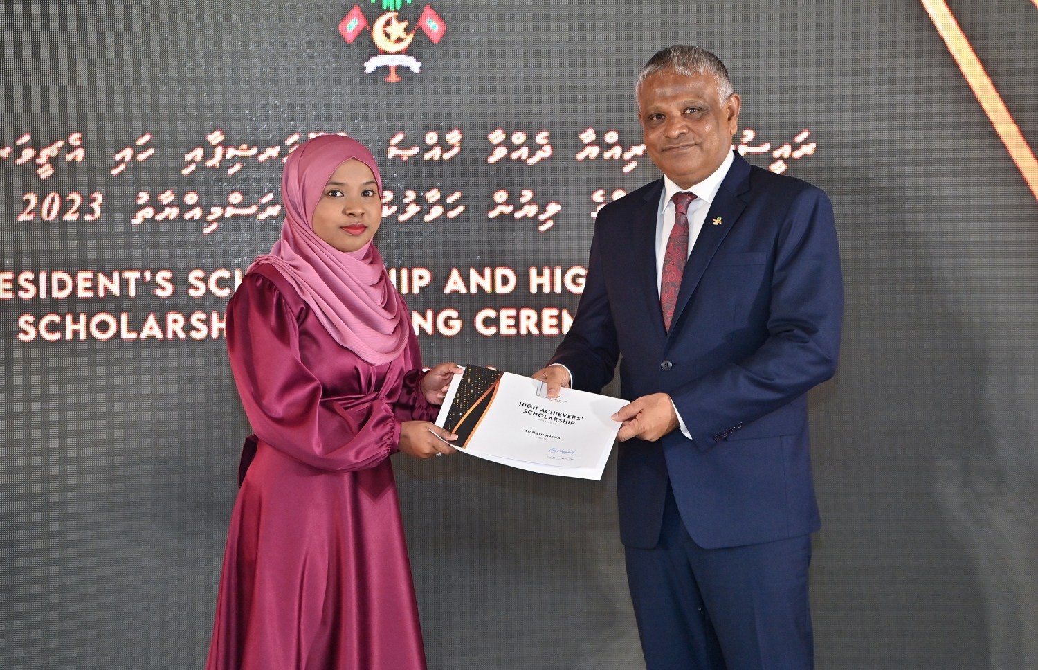 ރައީސްގެ އެވޯޑާއި ސްކޮލަޝިޕް ލިބުނު މަތީ ސާނަވީގެ ދަރިވަރުންނަށް ހަނދާނީ ލިޔުން ހަވާލުކުރުމަށް ބޭއްވި ރަސްމިއްޔާތުގައި ސްކޮލަޝިޕް ލިބުނު ދަރިވަރަކަށް ލިޔުން ހަވާލު ކުރައްވަނީ.-- ފޮޓޯ.-- ރައީސް އޮފީސް