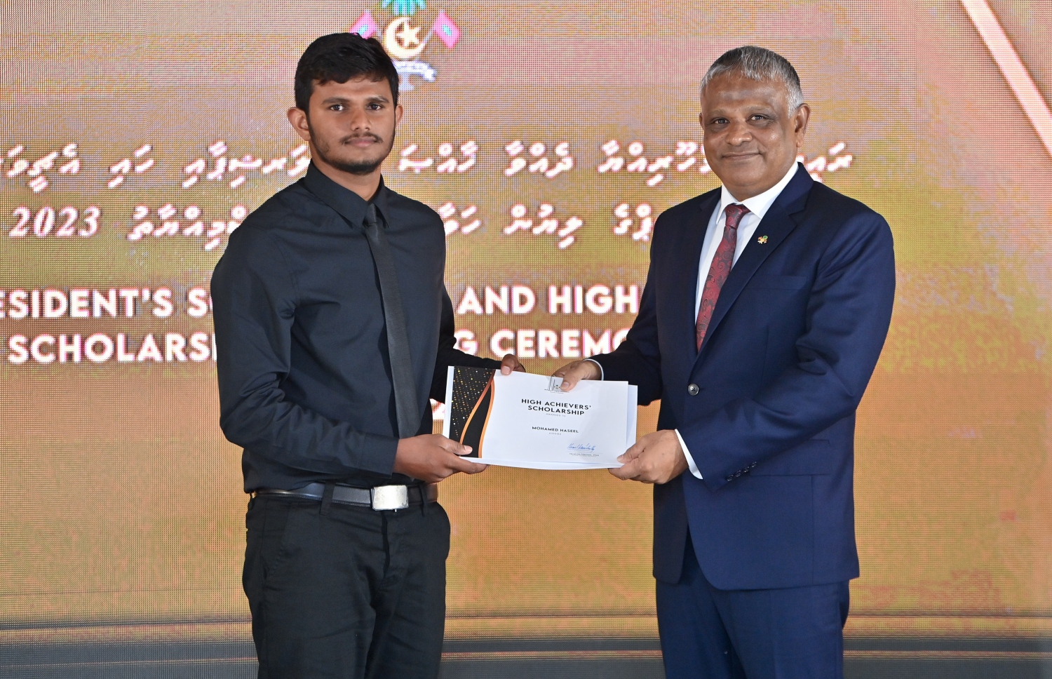 ރައީސްގެ އެވޯޑާއި ސްކޮލަޝިޕް ލިބުނު މަތީ ސާނަވީގެ ދަރިވަރުންނަށް ހަނދާނީ ލިޔުން ހަވާލުކުރުމަށް ބޭއްވި ރަސްމިއްޔާތުގައި ސްކޮލަޝިޕް ލިބުނު ދަރިވަރަކަށް ލިޔުން ހަވާލު ކުރައްވަނީ.-- ފޮޓޯ.-- ރައީސް އޮފީސް