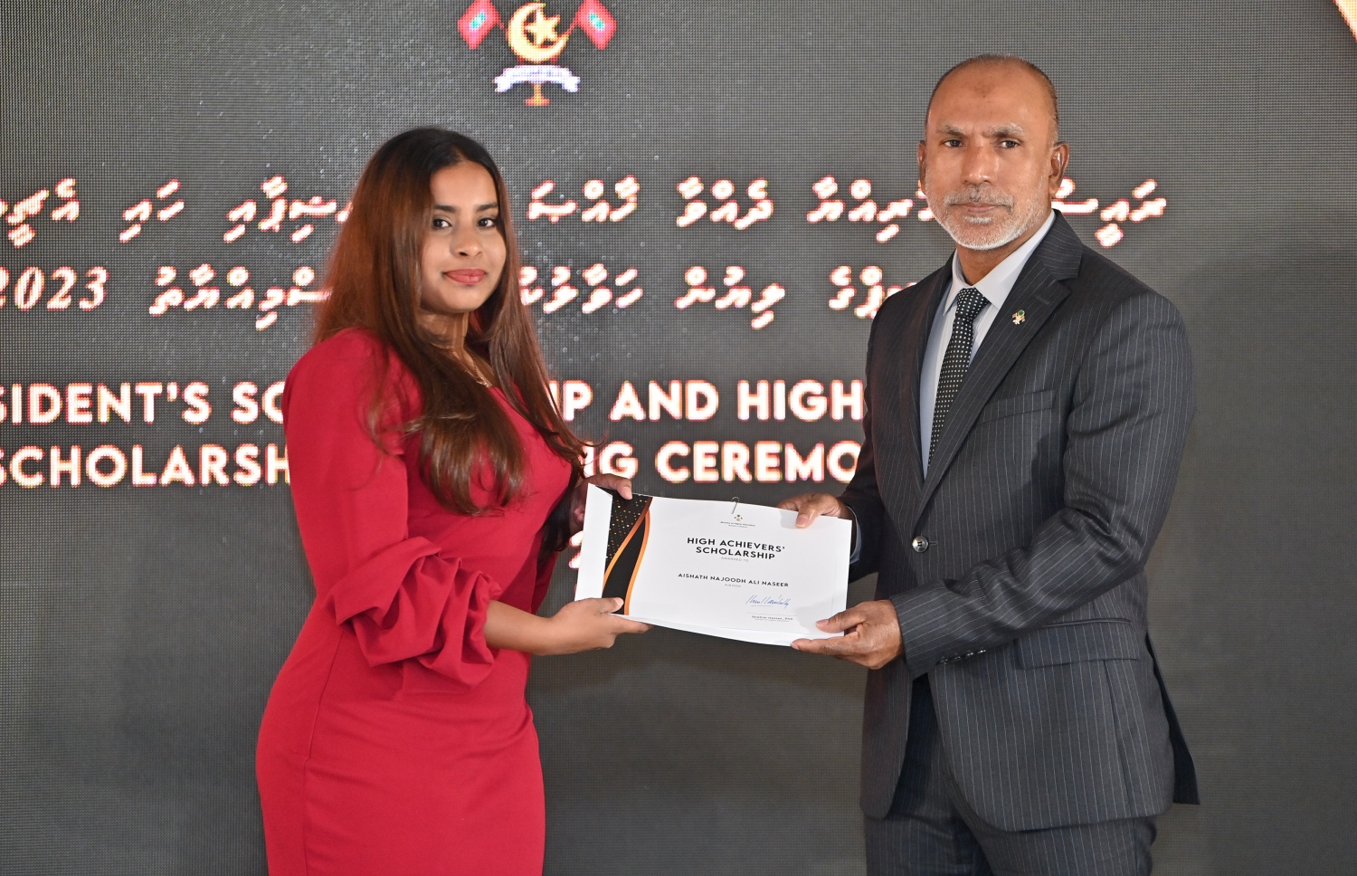 ރައީސްގެ އެވޯޑާއި ސްކޮލަޝިޕް ލިބުނު މަތީ ސާނަވީގެ ދަރިވަރުންނަށް ހަނދާނީ ލިޔުން ހަވާލުކުރުމަށް ބޭއްވި ރަސްމިއްޔާތުގައި ސްކޮލަޝިޕް ލިބުނު ދަރިވަރަކަށް ލިޔުން ހަވާލު ކުރައްވަނީ.-- ފޮޓޯ.-- ރައީސް އޮފީސް