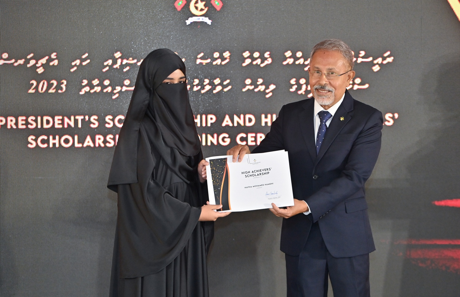 ރައީސްގެ އެވޯޑާއި ސްކޮލަޝިޕް ލިބުނު މަތީ ސާނަވީގެ ދަރިވަރުންނަށް ހަނދާނީ ލިޔުން ހަވާލުކުރުމަށް ބޭއްވި ރަސްމިއްޔާތުގައި ސްކޮލަޝިޕް ލިބުނު ދަރިވަރަކަށް ލިޔުން ހަވާލު ކުރައްވަނީ.-- ފޮޓޯ.-- ރައީސް އޮފީސް