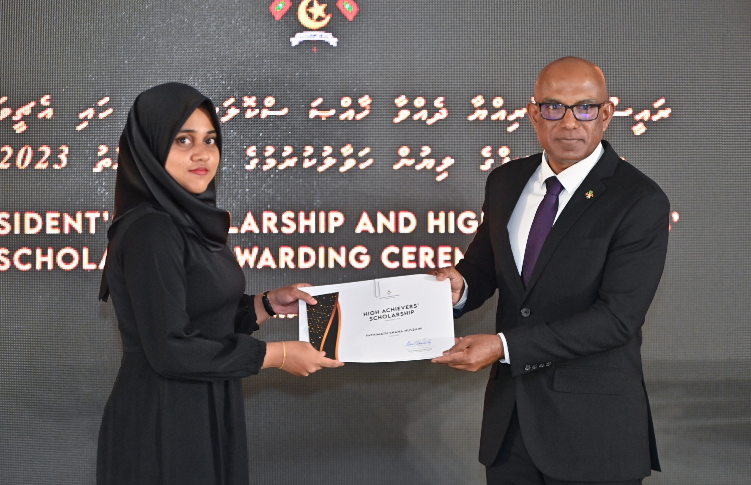 ރައީސްގެ އެވޯޑާއި ސްކޮލަޝިޕް ލިބުނު މަތީ ސާނަވީގެ ދަރިވަރުންނަށް ހަނދާނީ ލިޔުން ހަވާލުކުރުމަށް ބޭއްވި ރަސްމިއްޔާތުގައި ސްކޮލަޝިޕް ލިބުނު ދަރިވަރަކަށް ލިޔުން ހަވާލު ކުރައްވަނީ.-- ފޮޓޯ.-- ރައީސް އޮފީސް