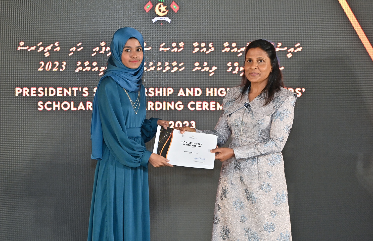 ރައީސްގެ އެވޯޑާއި ސްކޮލަޝިޕް ލިބުނު މަތީ ސާނަވީގެ ދަރިވަރުންނަށް ހަނދާނީ ލިޔުން ހަވާލުކުރުމަށް ބޭއްވި ރަސްމިއްޔާތުގައި ހައި އެޗީވާސް ސްކޮލަޝިޕް ލިބުނު ދަރިވަރަކަށް ފަސްޓްލޭޑީ ފަޒްނާ އަހުމަދު ލިޔުން ހަވާލު ކުރައްވަނީ.-- ފޮޓޯ.-- ރައީސް އޮފީސް