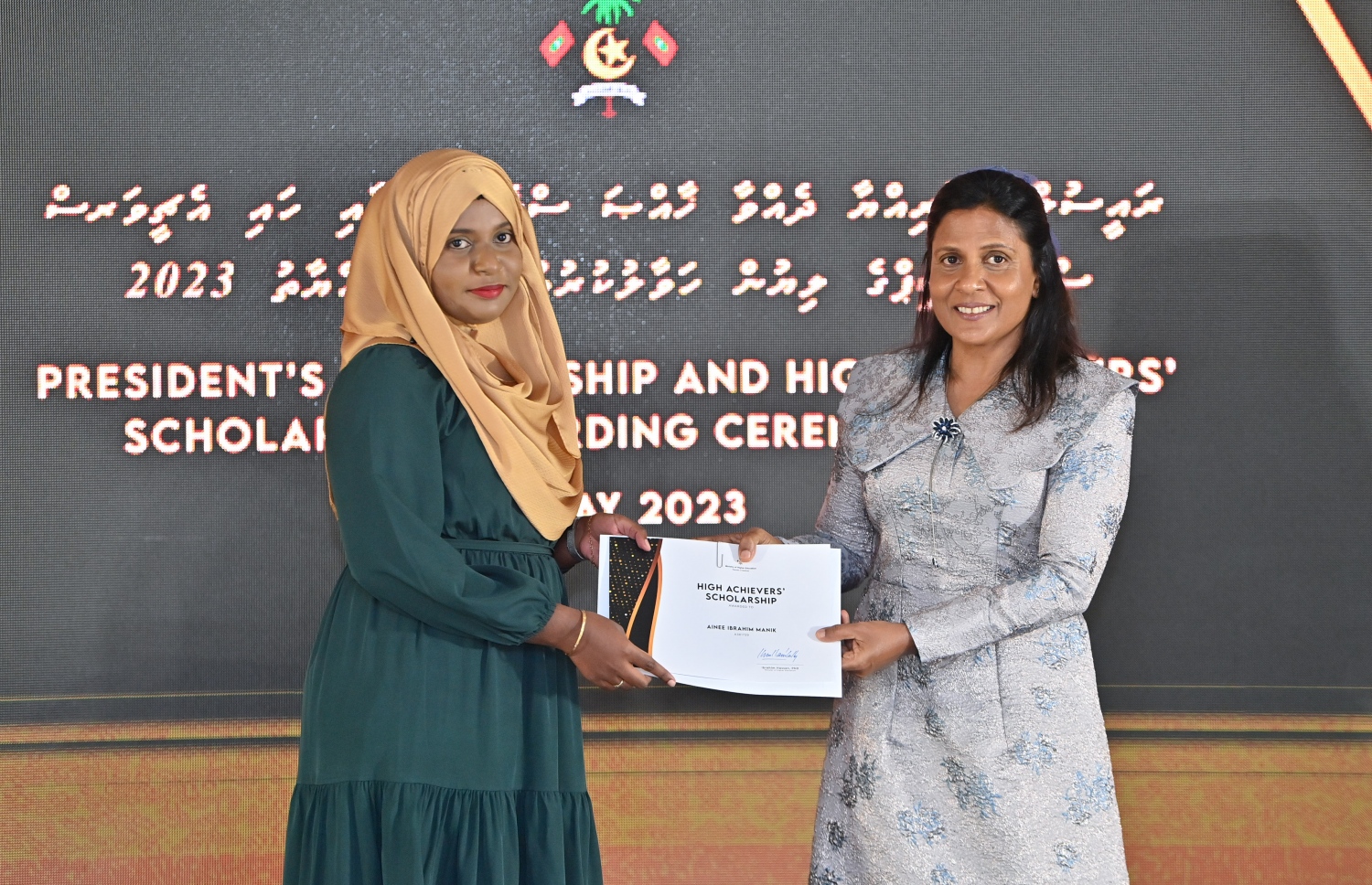 ރައީސްގެ އެވޯޑާއި ސްކޮލަޝިޕް ލިބުނު މަތީ ސާނަވީގެ ދަރިވަރުންނަށް ހަނދާނީ ލިޔުން ހަވާލުކުރުމަށް ބޭއްވި ރަސްމިއްޔާތުގައި ހައި އެޗީވާސް ސްކޮލަޝިޕް ލިބުނު ދަރިވަރަކަށް ފަސްޓްލޭޑީ ފަޒްނާ އަހުމަދު ލިޔުން ހަވާލު ކުރައްވަނީ.-- ފޮޓޯ.-- ރައީސް އޮފީސް