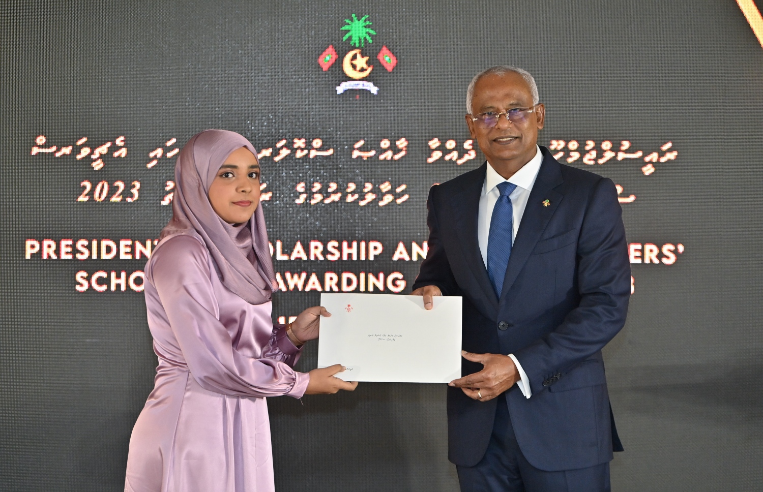 ރައީސްގެ އެވޯޑާއި ސްކޮލަޝިޕް ލިބުނު މަތީ ސާނަވީގެ ދަރިވަރުންނަށް ހަނދާނީ ލިޔުން ހަވާލުކުރުމަށް ބޭއްވި ރަސްމިއްޔާތުގައި މަތީ ސާނަވީ އިމްތިހާނުން އެއްވަނަ ލިބުނު ދަރިވަރަކަށް ރައީސް އިބްރާހިމް މުހައްމަދު ސޯލިހު ލިޔުން ހަވާލު ކުރައްވަނީ.-- ފޮޓޯ.-- ރައީސް އޮފީސް