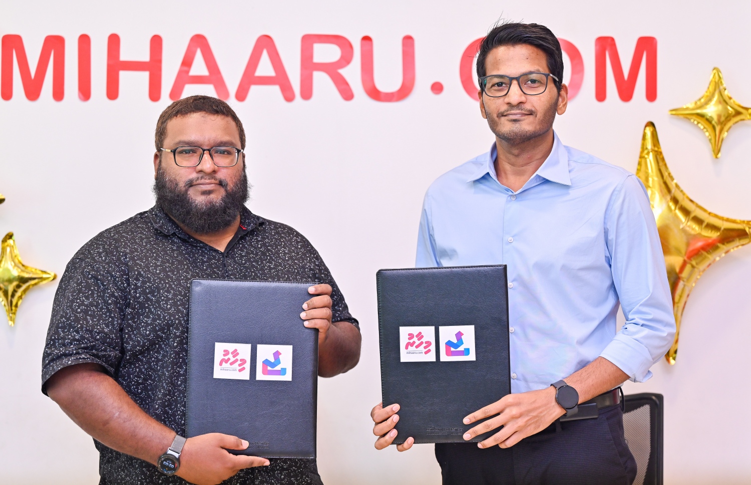 އޯޑިއޯ ނިއުސް ޑިވެލޮޕްކުރި "ޖަވާބު" ކުންފުނީގެ މެނޭޖިން ޑިރެކްޓަރު މުހައްމަދު ޖައިލަމް އާއި "މިހާރު"ގެ ސީއޯއޯ ހަސަން މާހިރު (ކ) އެއްބަސްވުމުގައި ސޮއިކުރުމަށް ފަހު ފޮޓޯއަކަށް ހުއްޓިގެން. -- ފޮޓޯ: މިހާރު