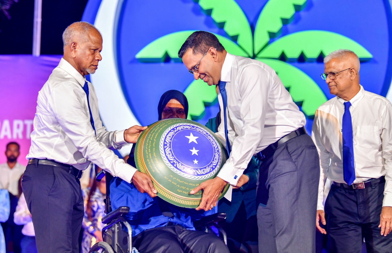 އެމްއެންޕީގެ ރިޔާސީ ޓިކެޓާ އެ ޕާޓީގެ ރައީސް މުހައްމަދު ނާޒިމް ހަވާލުވެވަޑައިގަންނަވަނީ: އިންތިހާބުގައި އެމްއެންޕީ ބޭނުންކުރާނެ ލޯގޯއާ ސްލޯގަން ވެސް ވަނީ ދައްކައިލި. -- ފޮޓޯ: ފަޔާޒު މޫސާ | މިހާރު