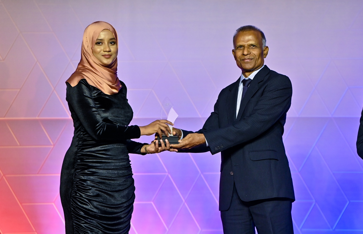 އޭލެވެލް އިމްތިހާނުގެ ގަދަ 10 ގައި ހިމެނުނު ކުދިންނަށް އިނާމު ދިނުމަށް ދަރުބާރުގޭގައި ބޭއްވި ރަސްމިއްޔާތުގައި، ގައުމީ ޔުނިވަސިޓީގެ ޗާންސެލާ ޑރ. ހަސަން ހަމީދު ދަރިވަރަކަށް އެވޯޑު ހަވާލު ކުރައްވަނީ.-- ފޮޓޯ: ރައީސް އޮފީސް