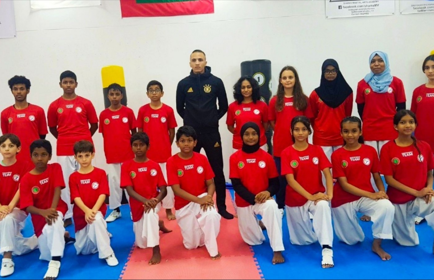 ކިނާން، އޭނާ ރާއްޖޭގައި ތަމްރީނުކުރާ ބައެއް ކުދިންނާ އެކު.--