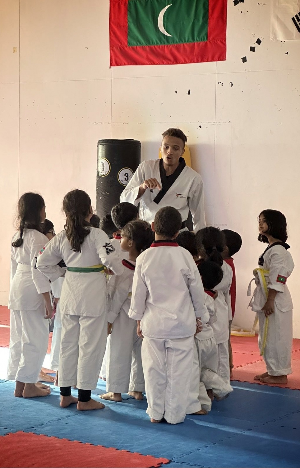 ކިނާން، ޝާކްސް އެކަޑަމީ ކްލާހުގައި ކުޑަކުދިންތަކެއް ތަމްރީނު ކުރުމުގައި.--