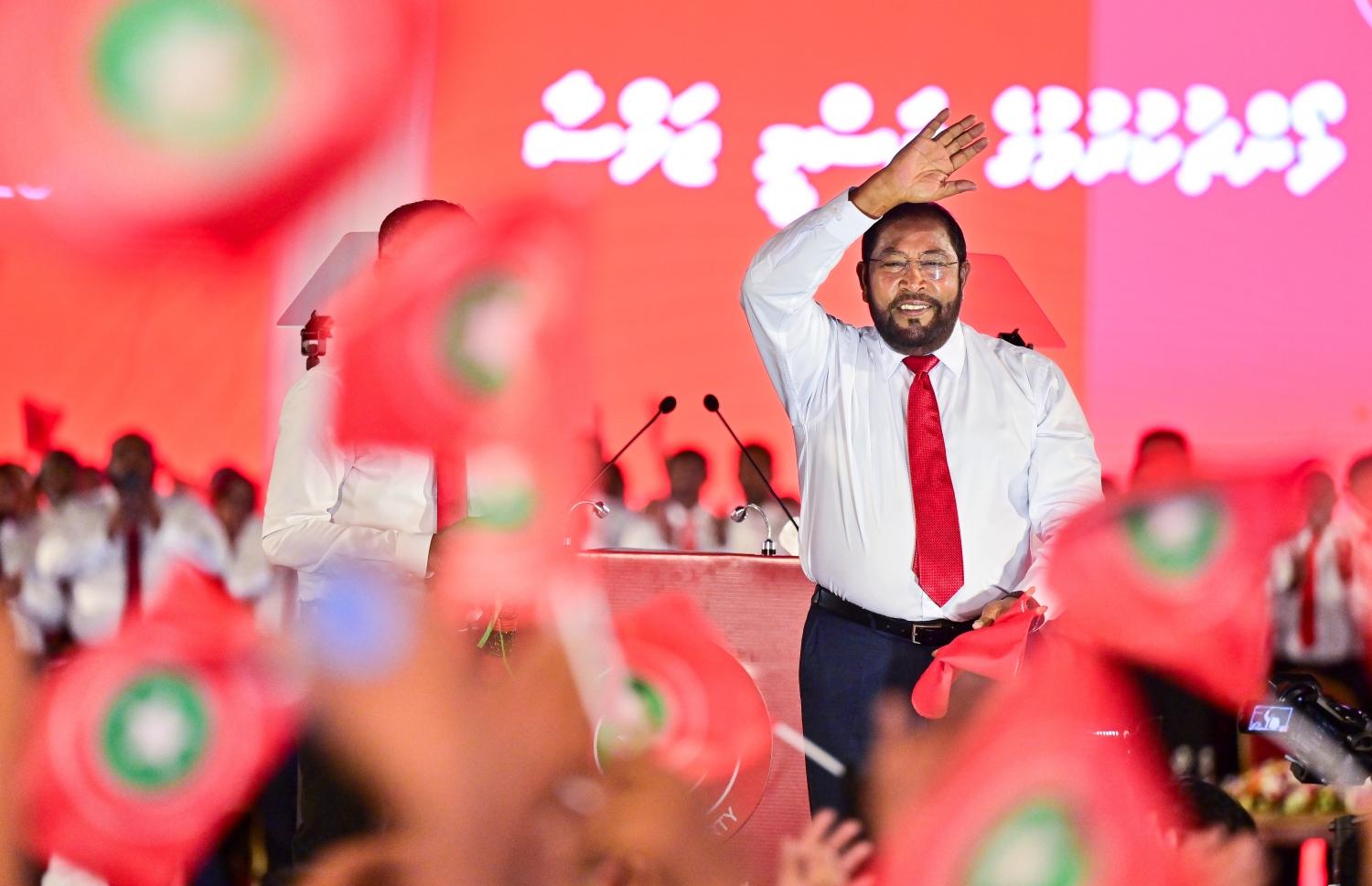 ޖޭޕީގެ ރިޔާސީ ޓިކެޓާ ހަވާލުވެވަޑައިގަތުމަށް ފަހު، ޖަލްސާގެ ބައިވެރިންނަށް ގާސިމް އަތް ހިއްލާލައްވައި ސަލާމް ކުރައްވަނީ.--- ފޮޓޯ: ފަޔާޒު މޫސާ | މިހާރު
