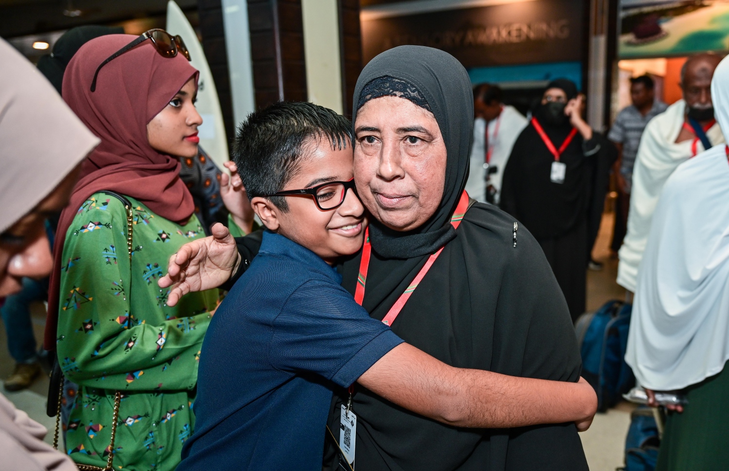 ރާއްޖެ އިން މި އަހަރު ހައްޖަށް ދާ މީހުންގެ ފުރަތަމަ ގުރޫޕުގެ މީހަކު މިއަދު ފުރުމުގެ ކުރިން އޭނާގެ އާއިލާ ކުއްޖެއްގެ ގައިގައި ބައްދާލަނީ.--- ފޮޓޯ: ފަޔާޒު މޫސާ | މިހާރު