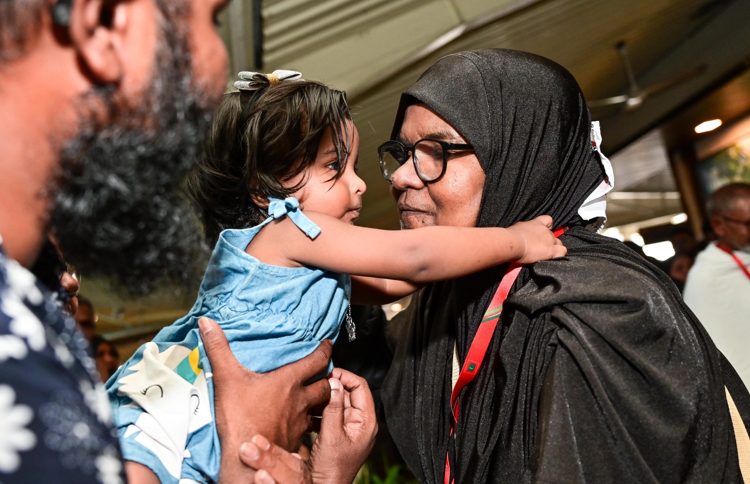 ރާއްޖެ އިން މި އަހަރު ހައްޖަށް ދާ މީހުންގެ ފުރަތަމަ ގުރޫޕުގެ މީހަކު މިއަދު ފުރުމުގެ ކުރިން ކުޑަކުއްޖެއްގެ ގައިގައި ބައްދާލަނީ -- ފޮޓޯ: ފަޔާޒު މޫސާ | މިހާރު