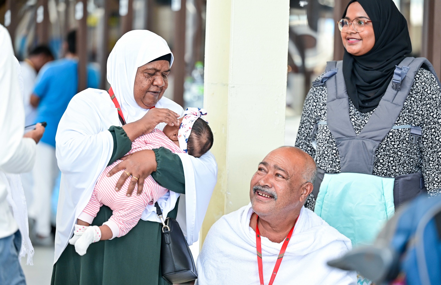 ރާއްޖެ އިން ހައްޖަށް ދާ ދެ މީހަކު މިއަދު ފުރުމުގެ ކުރިން، އެ މީހުންގެ އާއިލާގެ ތުއްތު ކުއްޖެއްގެ ގައިގައި ބައްދާލައި ލޯބިކޮށްލަނީ: މި އަހަރު ރާއްޖެއިން 1،000 މީހުން ހައްޖަށް ދާނެ.--- ފޮޓޯ: ފަޔާޒު މޫސާ | މިހާރު